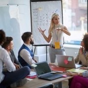 Business woman present her idea to working team workshopping software development idea